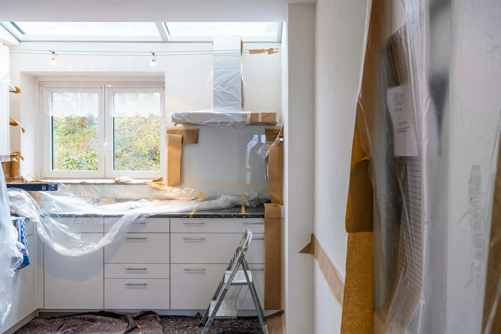 Kitchen renovation in progress with cabinets fitted and walls open