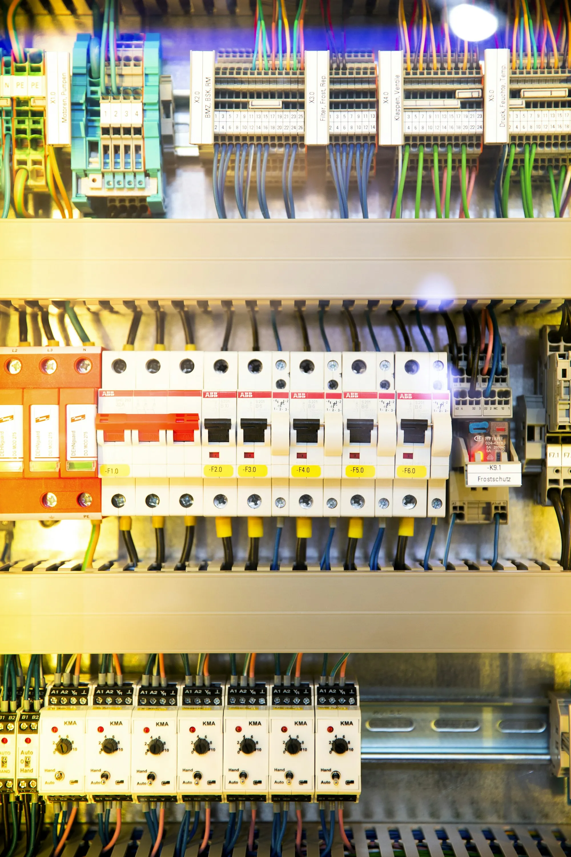 Rows of breakers and cabling inside an open electrical cabinet