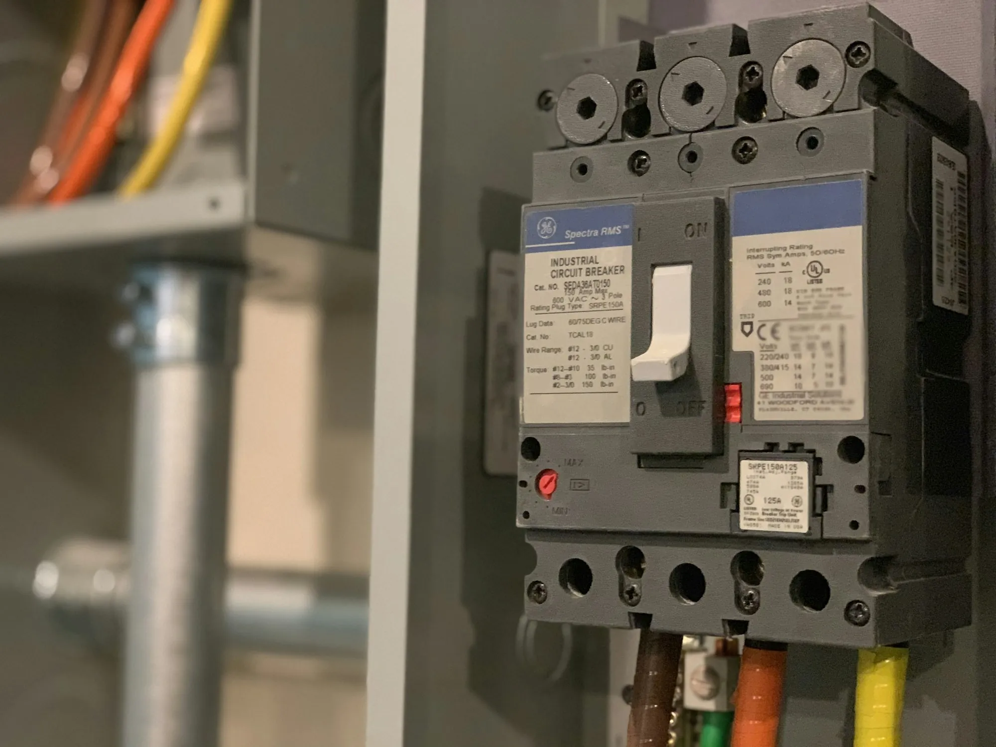 Industrial circuit breaker mounted in a gray electrical enclosure