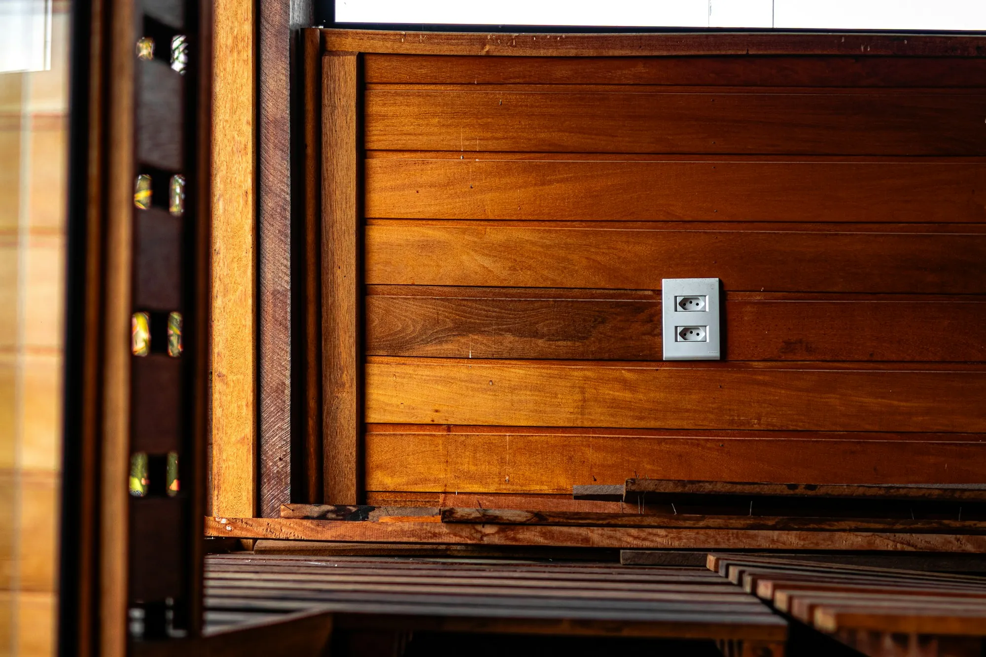Single new outlet fitted into a warm wood-paneled wall