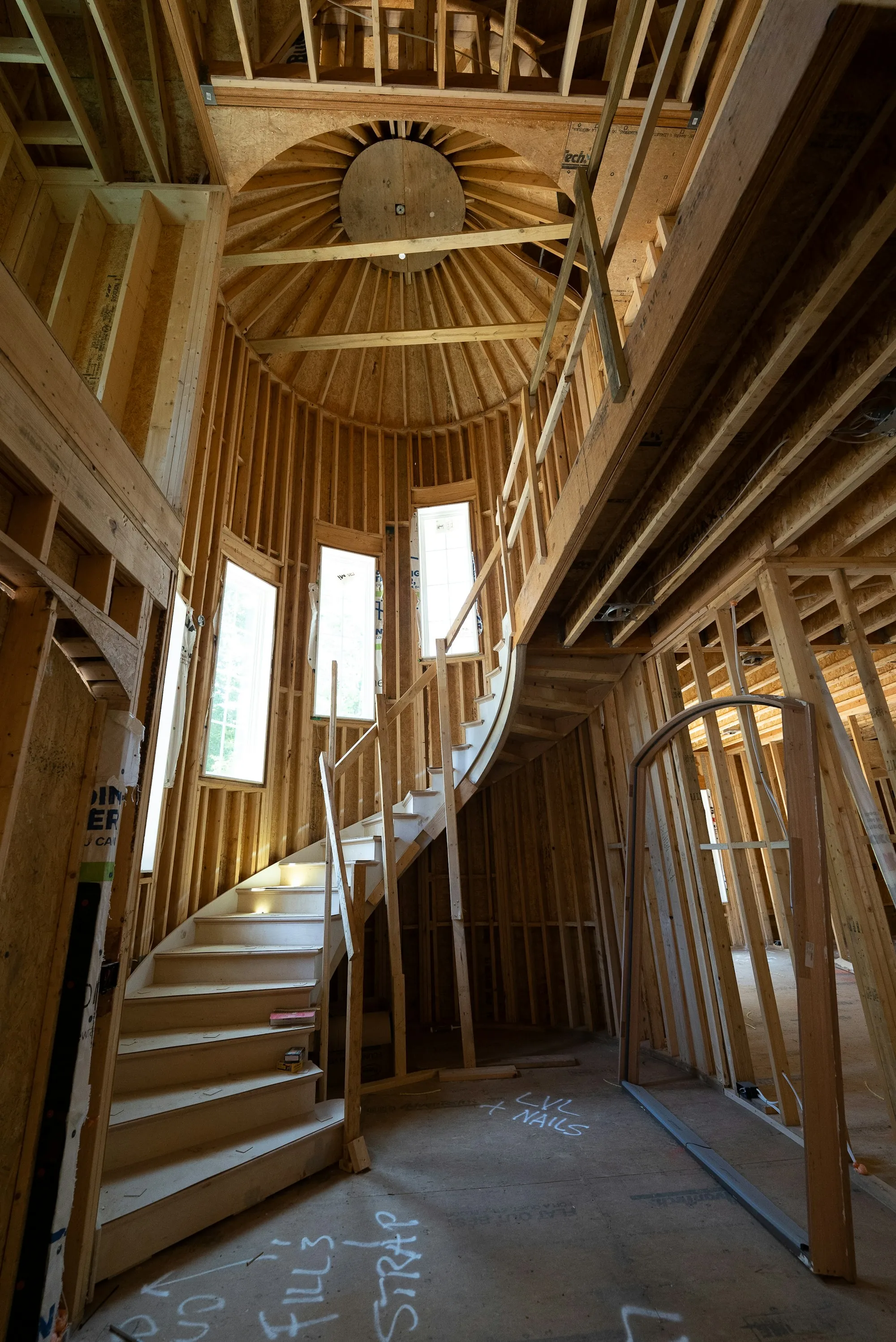 Unfinished interior with exposed timber framing and a staircase